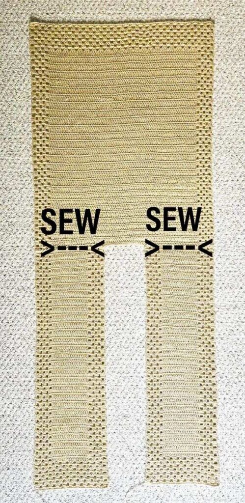 The crochet ruana is laid flat on the floor showing you how to sew the shoulder seams.