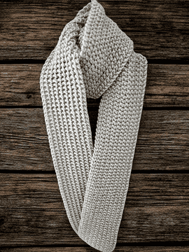 The knitted scarf is laid down on a wooden table showing the two sides.