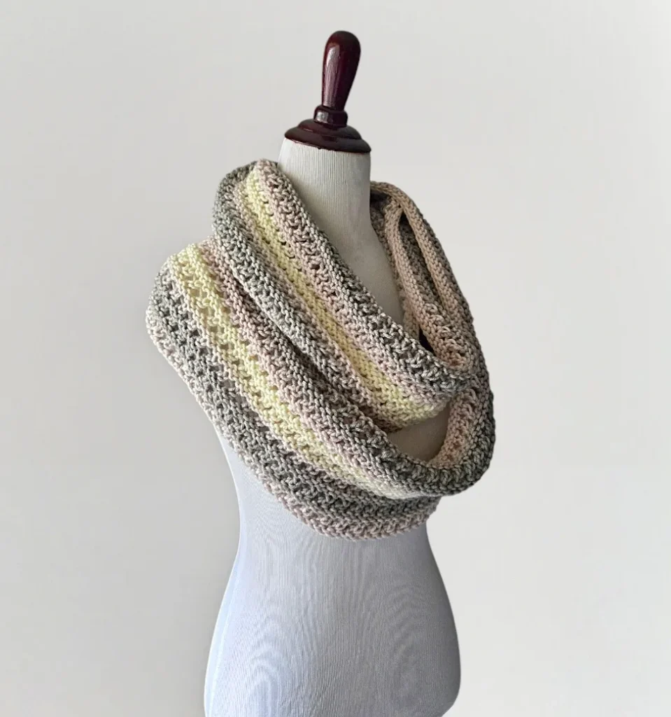 Free knitting pattern for an easy eyelet Infinity Scarf styled on a mannequin.