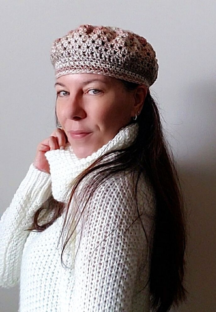 Front view of a model wearing the Granny Crochet Beret, a textured slouchy hat handmade with variegated yarn.
