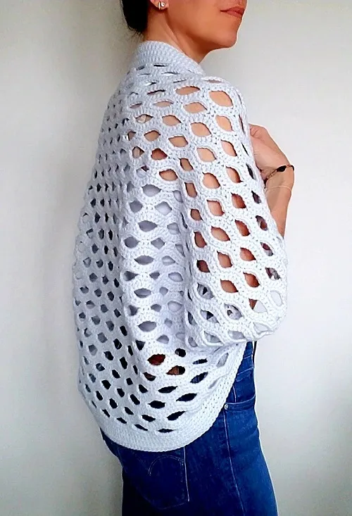 A woman wearing an Open Shell Cocoon cardigan in light gray.