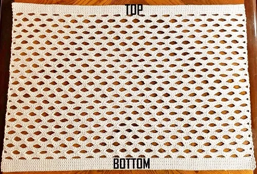 The cocoon crochet cardigan is laid out on the floor showing how it is constructed and the open shell design.
