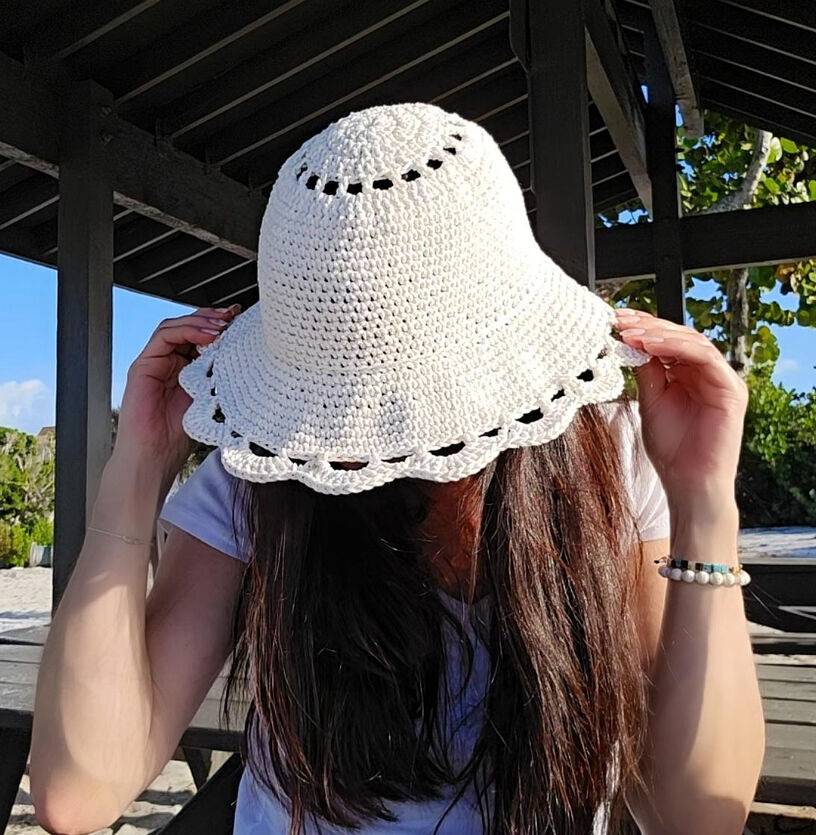 The model is showing the top section of the crochet sun hat and the wide sturdy brim.